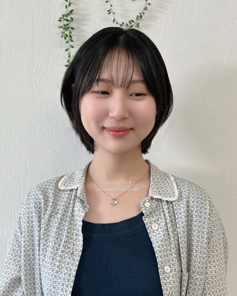 Rounded black layered bob with soft see-through bangs and a smooth finish.
