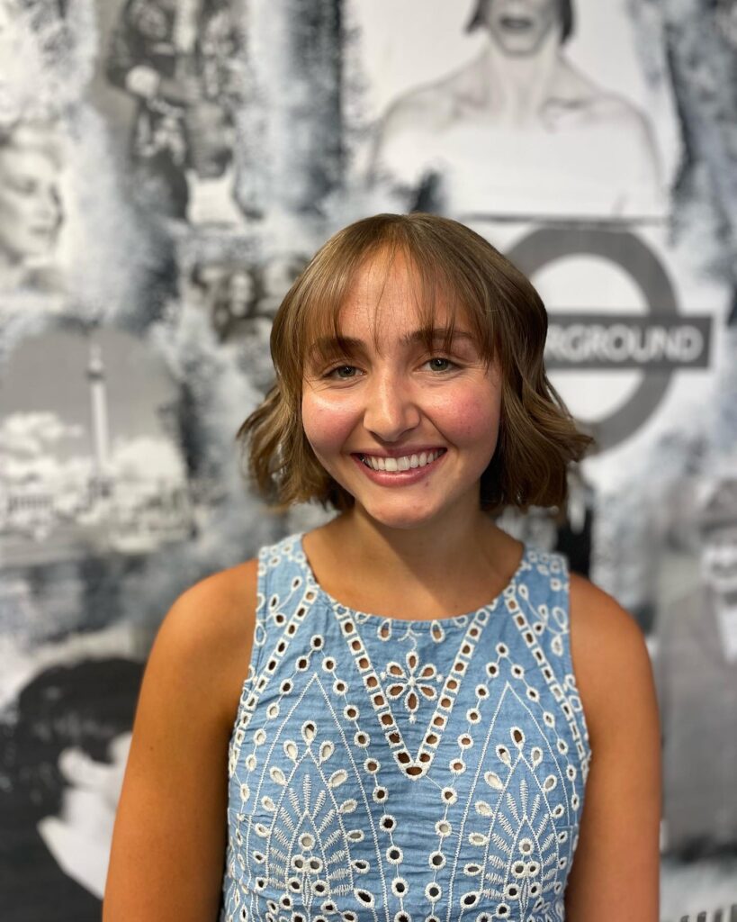 A wavy chin-length bob with baby bangs and soft textured layers.