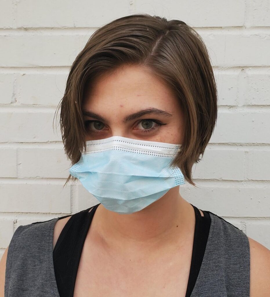 Short tapered layered bob with a side part and smooth brunette styling.