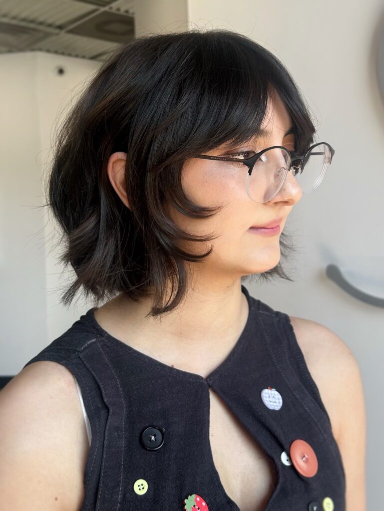 Black layered bob with flipped ends, feathered fringe, and soft texture.