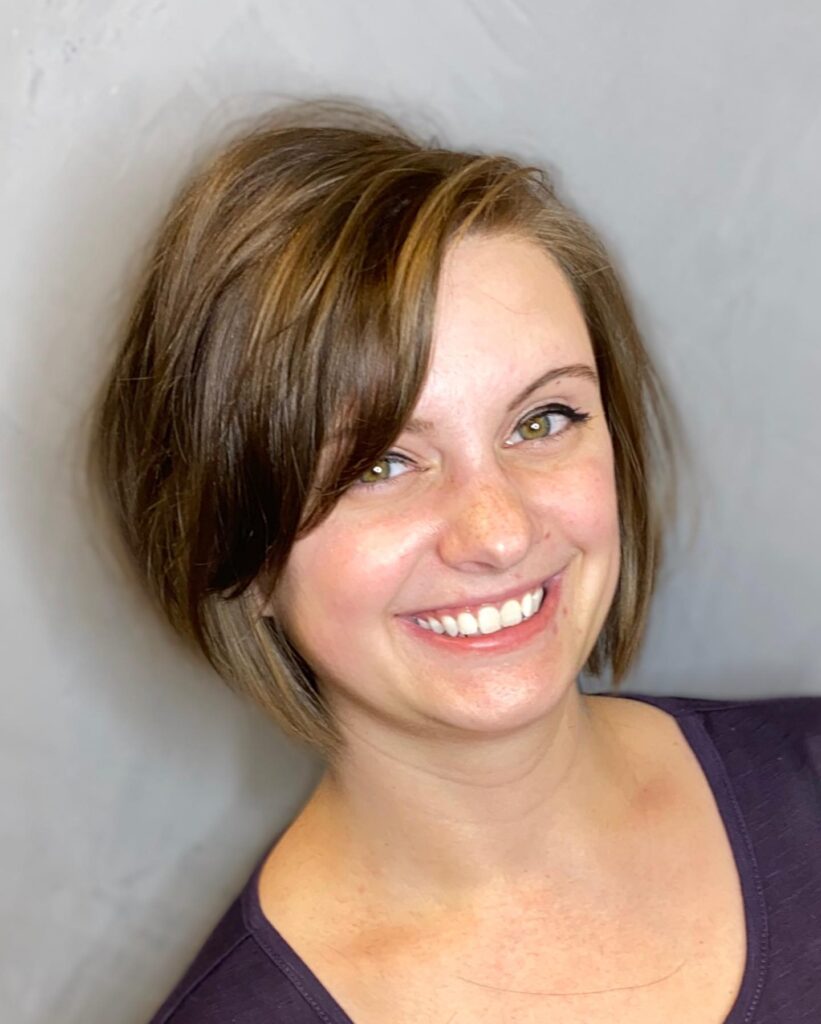 Short brunette bob with a long side fringe and sleek rounded layers.