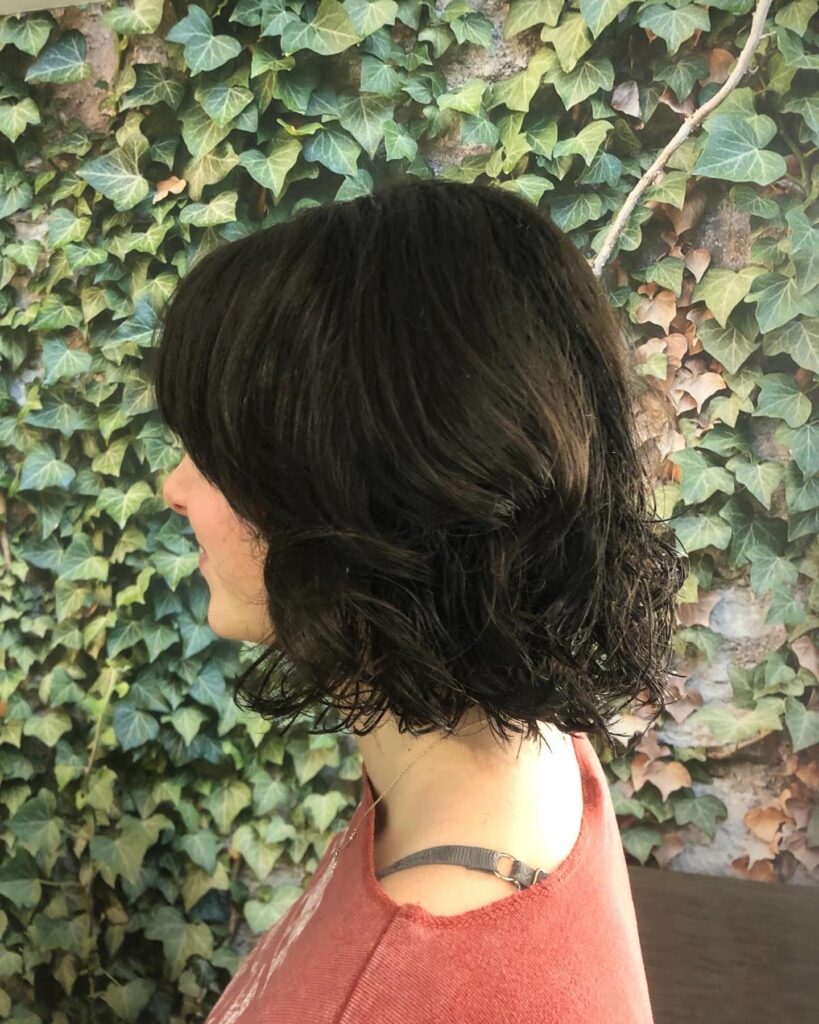 Rounded dark brunette layered bob with soft volume and curved ends.