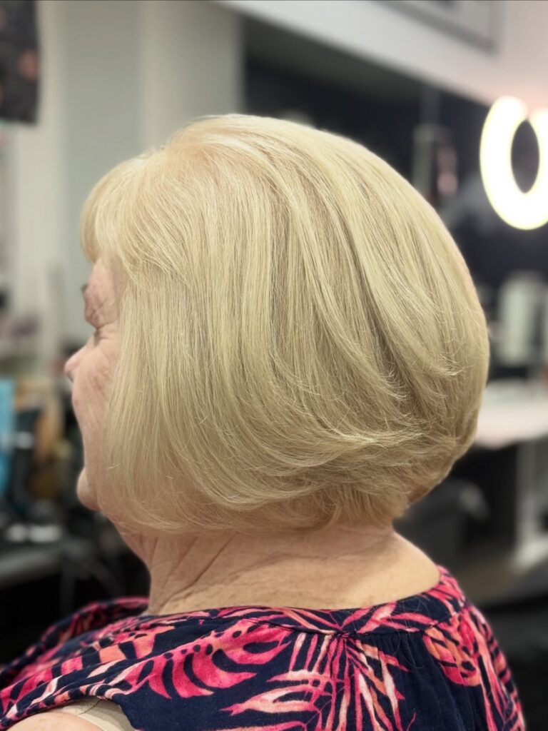 Rounded champagne blonde bob with smooth layers and softly curved ends.