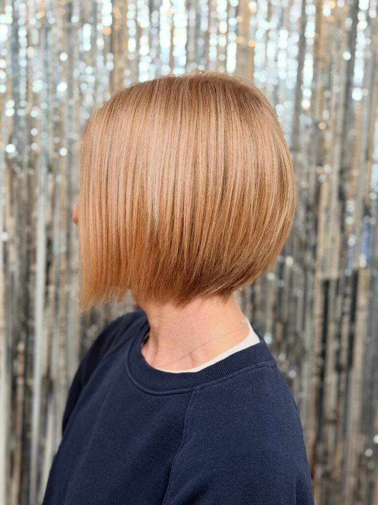 Sleek angled blonde bob with stacked layers in the back and longer front sections.