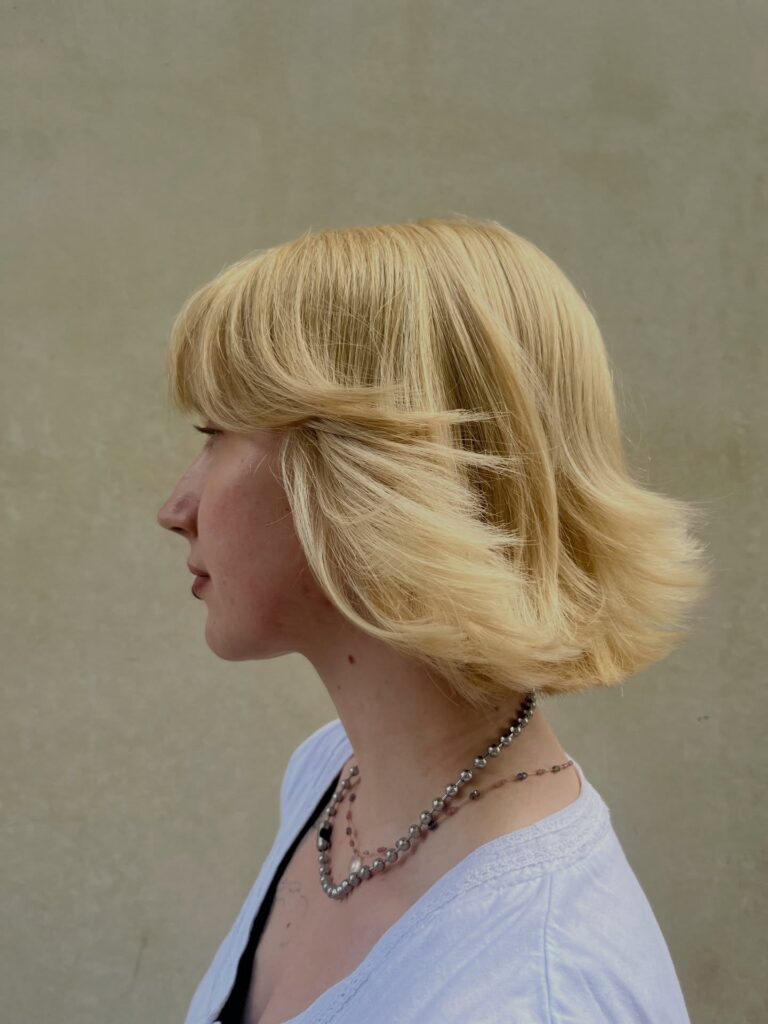Retro blonde bob with airy feathered layers and softly flipped ends.