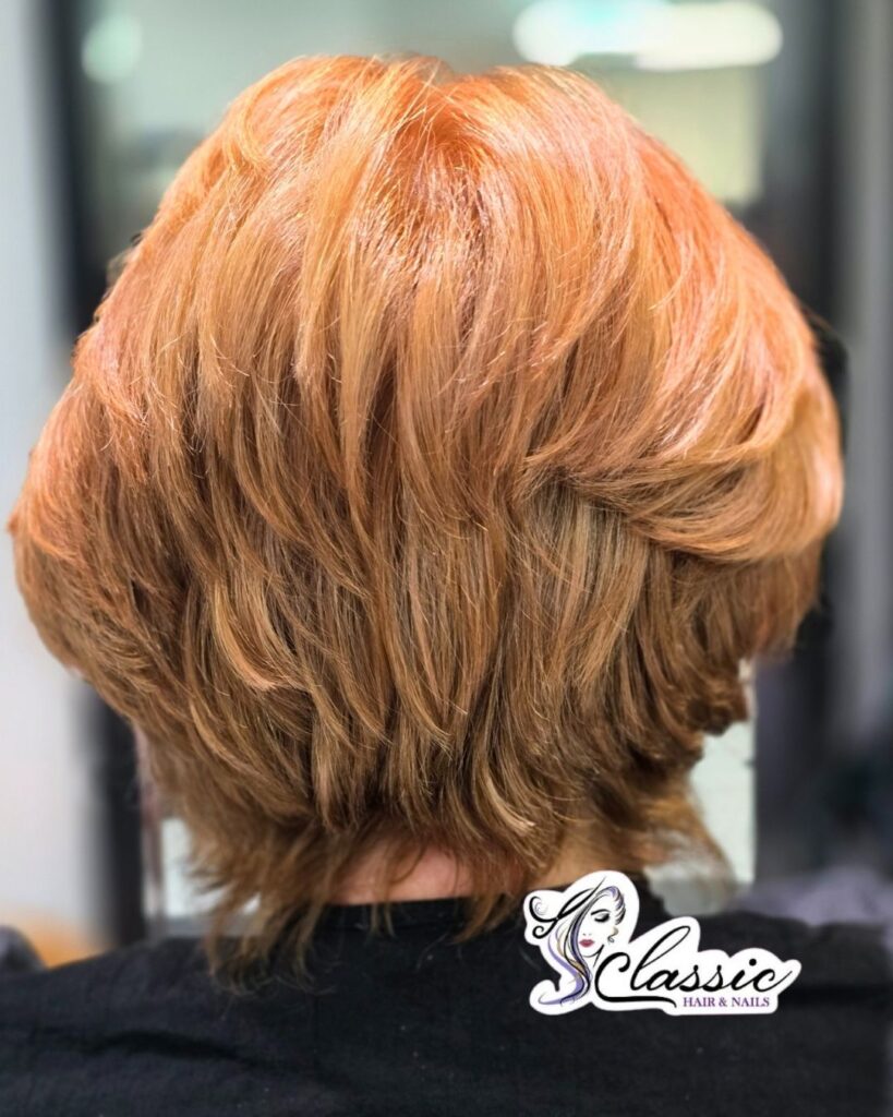 Copper blonde layered bob with textured stacked layers and warm dimensional color.