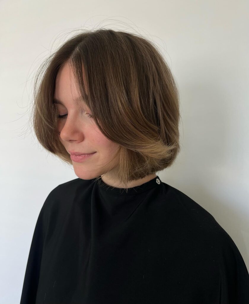 Layered mushroom brown bob with feathered ends and subtle beige highlights.
