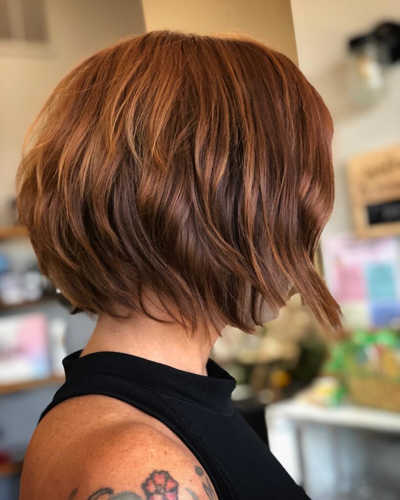 Textured copper brown bob with warm cinnamon highlights and soft layers.