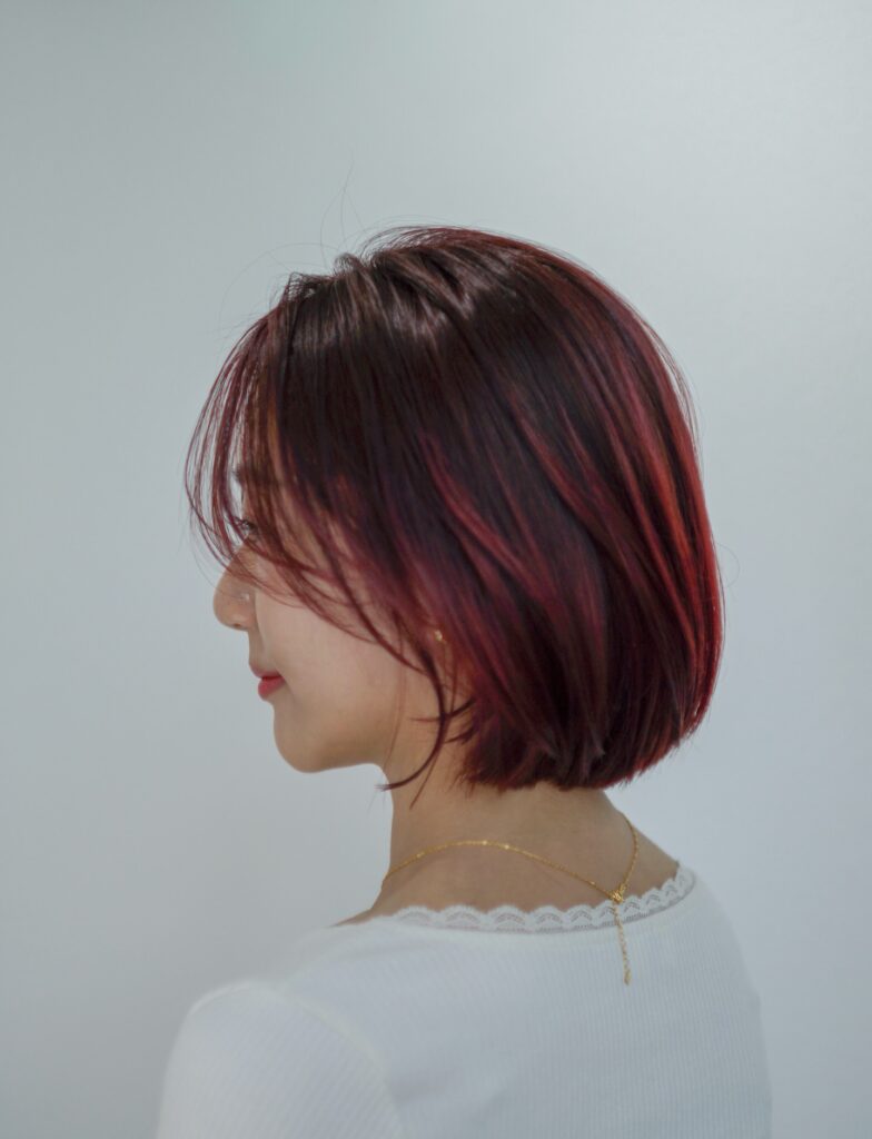 Glossy cherry red bob with subtle layers and bright red highlights.
