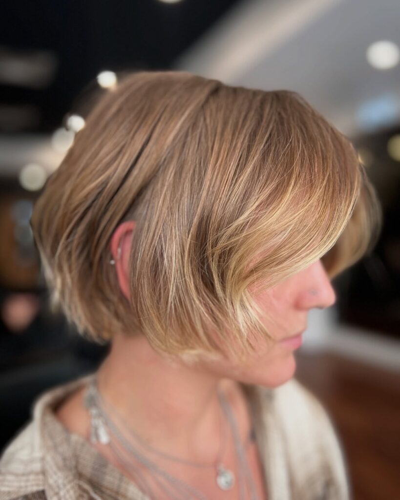 Beige blonde bob with face-framing layers and soft dimensional highlights.