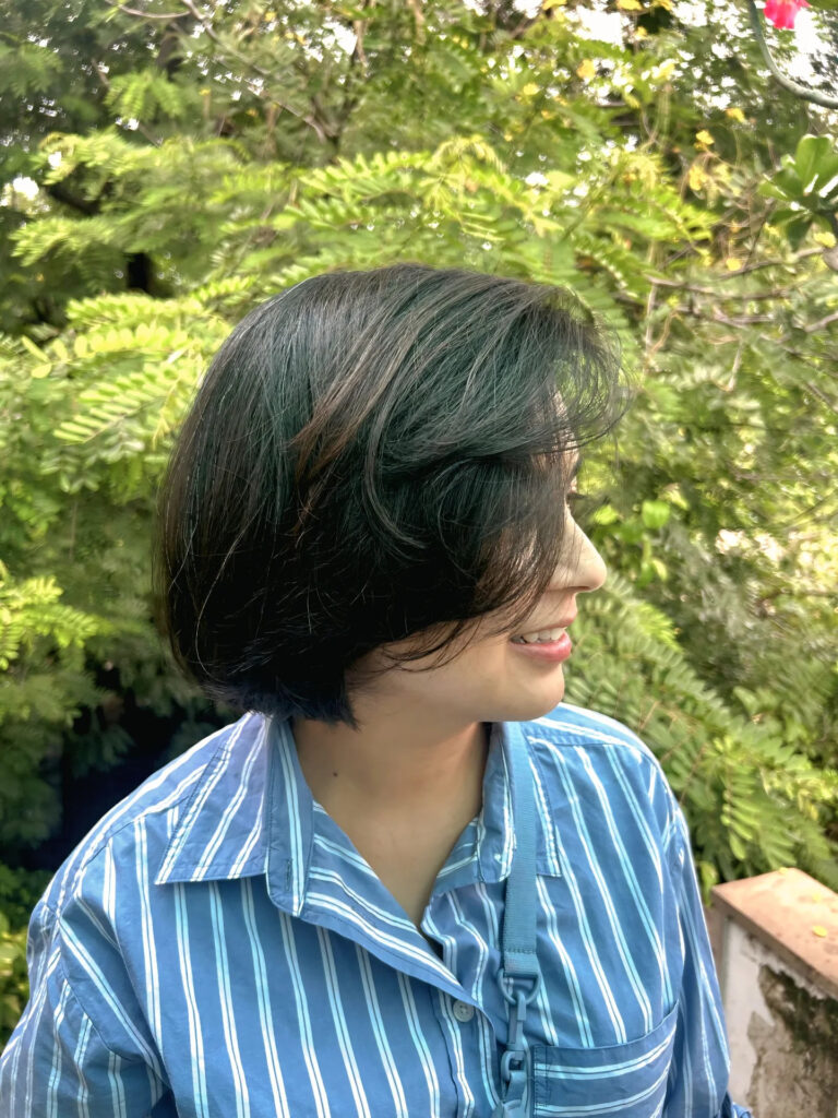 Black layered bob with subtle dark green highlights and soft rounded layers.