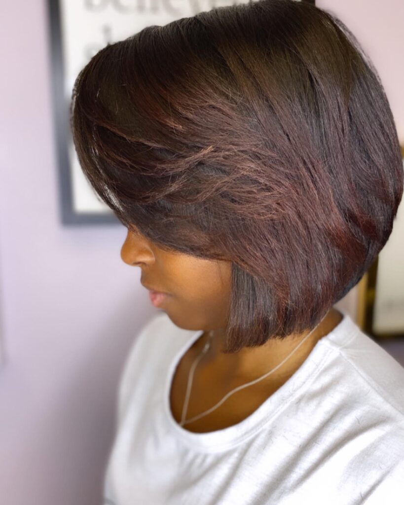 Espresso brown layered bob hairstyle with feathered side swept layers and a sleek finish.