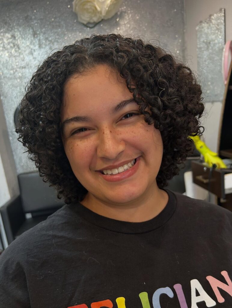 Dark curly bob with spiral ringlets and a rounded layered shape.