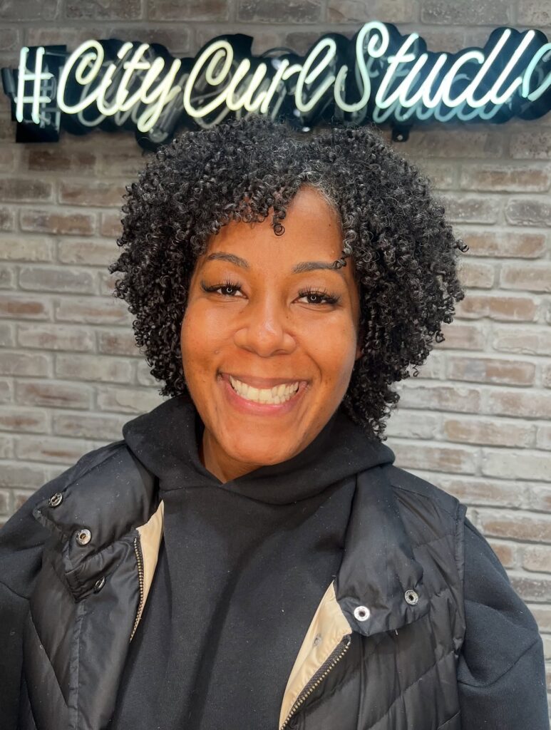 A rounded curly bob with tight, defined micro-curls and natural volume.
