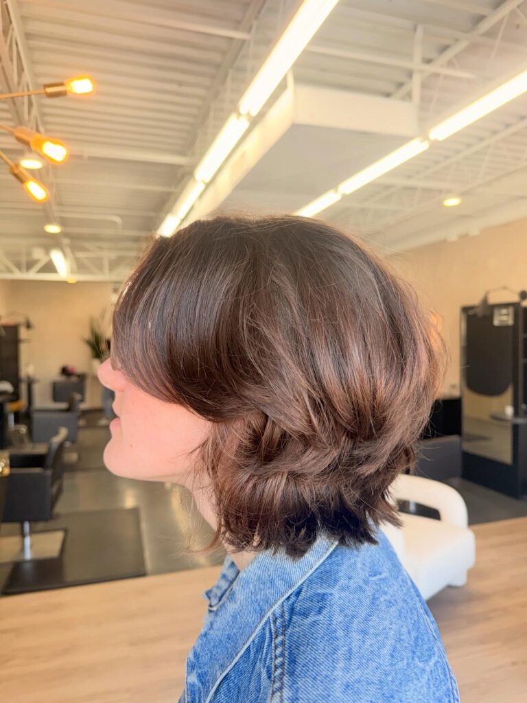 Chocolate brown layered bob with airy curtain bangs and tousled texture.