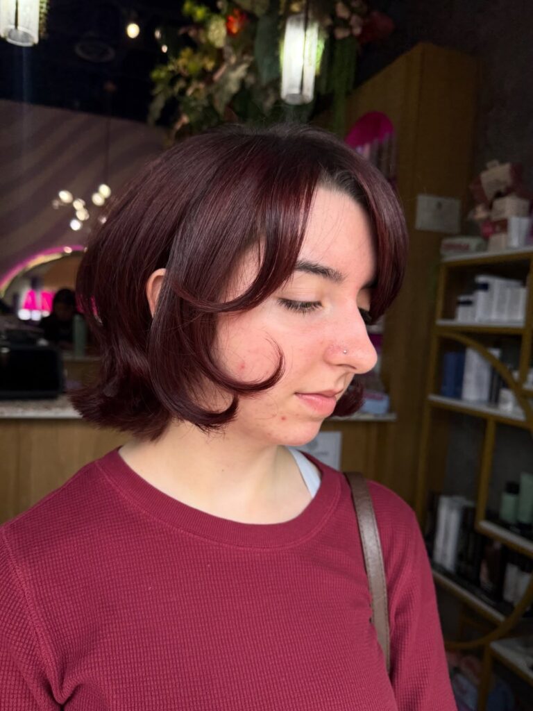 Cherry cola layered bob with curled curtain bangs and flipped-out ends.