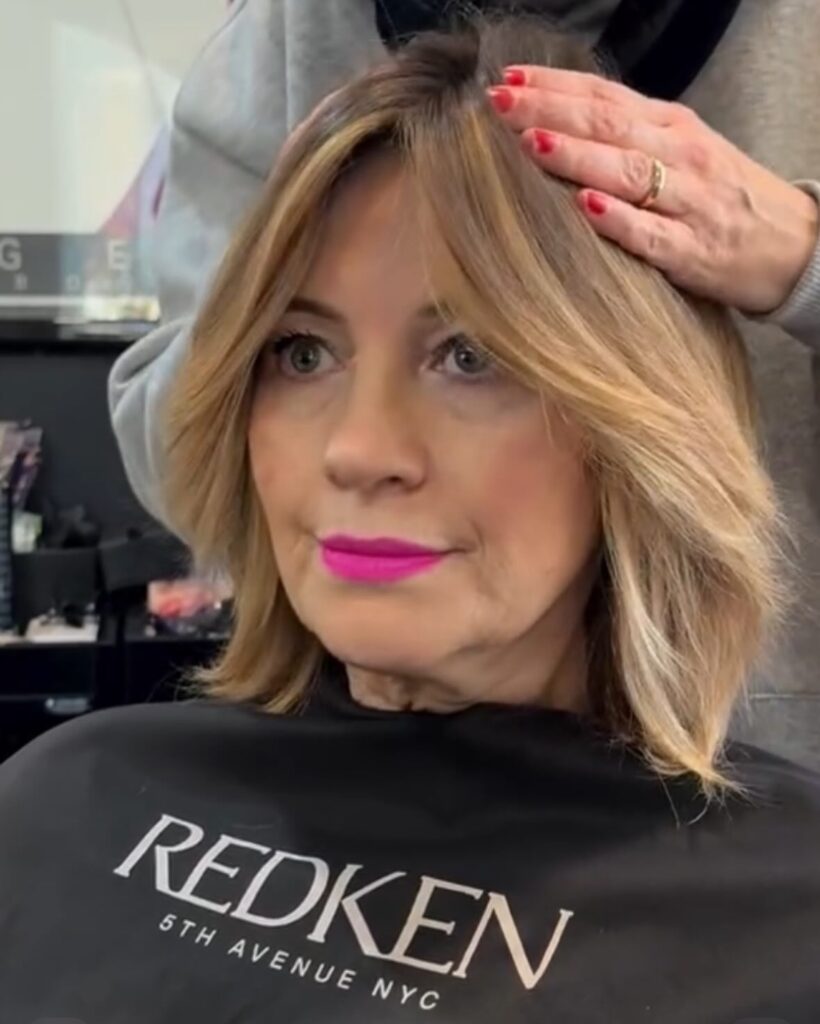 Warm blonde layered bob with wispy curtain bangs and soft textured ends.