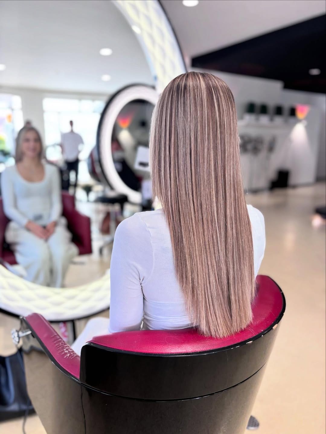 Long, sleek ash-blonde hair styled pin-straight with subtle face-framing layers and softly tapered ends, creating a smooth and polished finish.