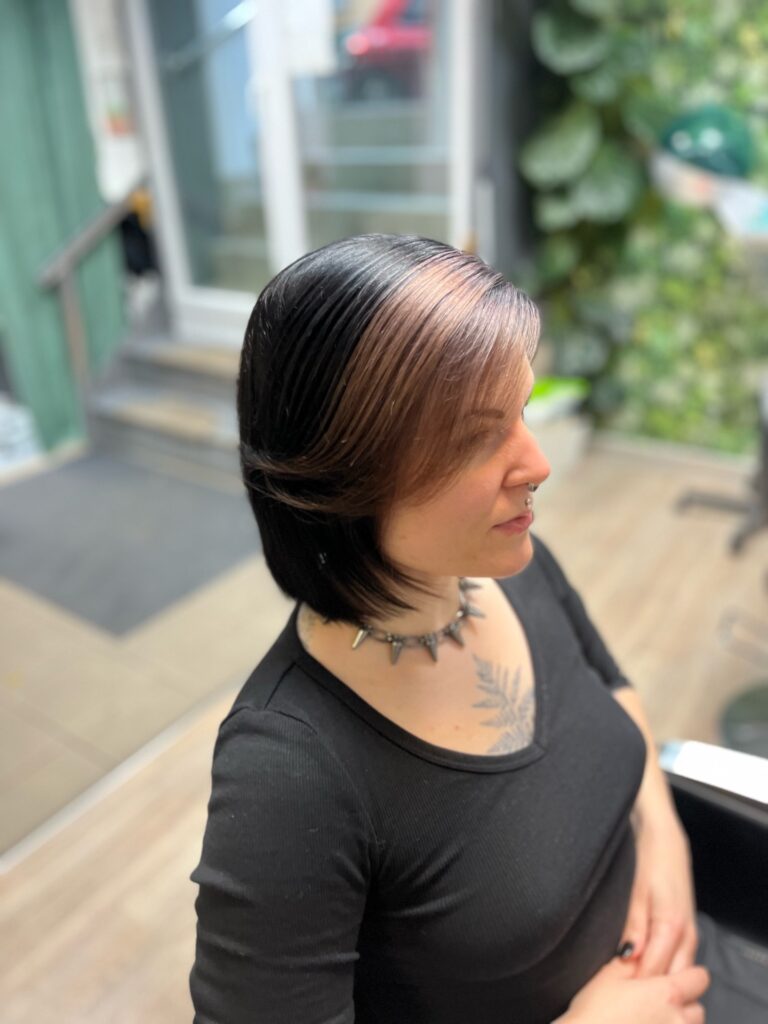 A woman with a short black bob and a light, ashy blonde money piece swept to the side.