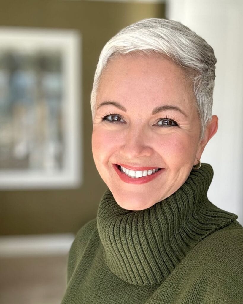 Short silver pixie cut with soft volume on top and neatly tapered sides, styled smoothly for a polished, modern look.