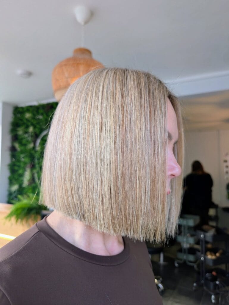 Straight shoulder-length blonde blunt bob with a clean, even cut and smooth sleek finish for a polished modern look.