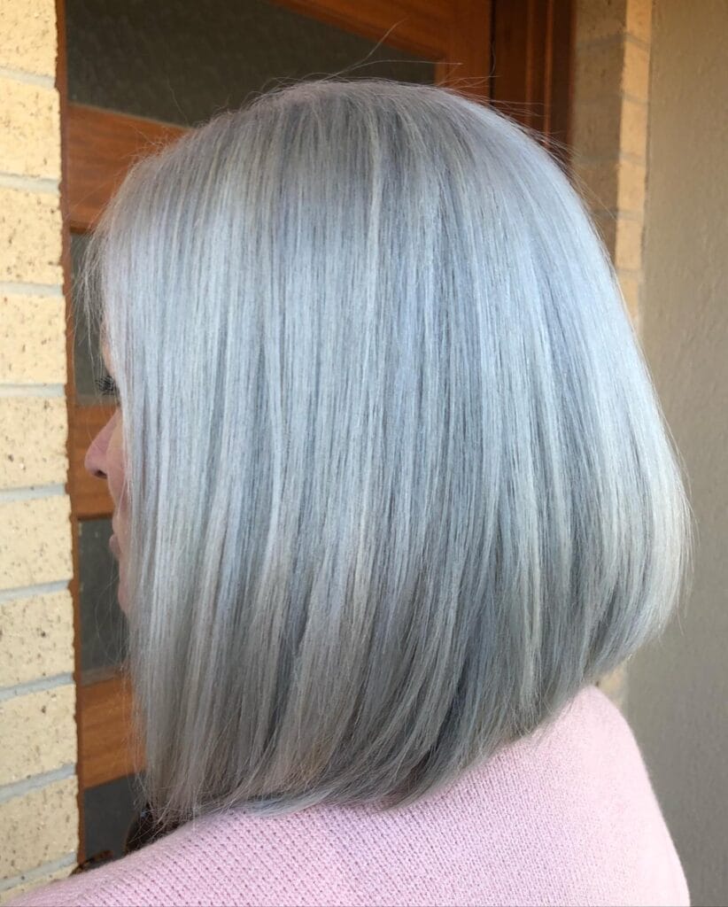 Side view of a smooth shoulder-length silver bob with straight, softly layered ends and a natural, sleek finish.