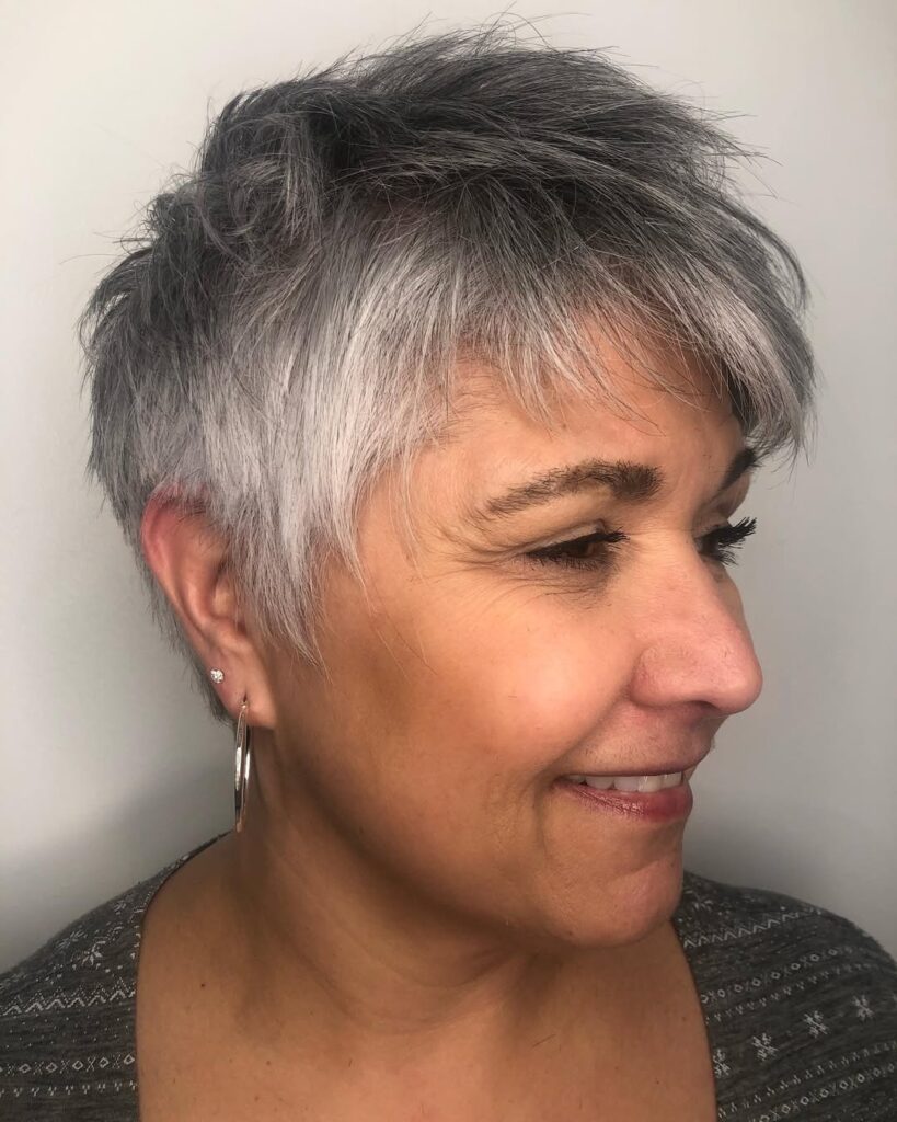 Short silver pixie haircut with choppy layers and a feathered fringe.