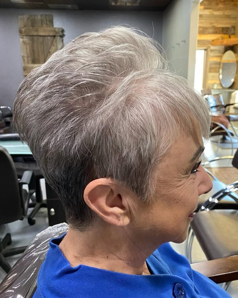 Short gray pixie cut with soft layers and side swept bangs.
