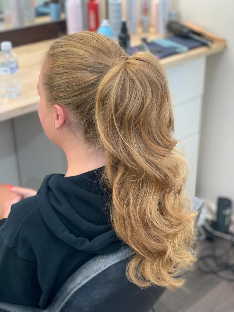 High ponytail with long wavy hair and a smooth crown.