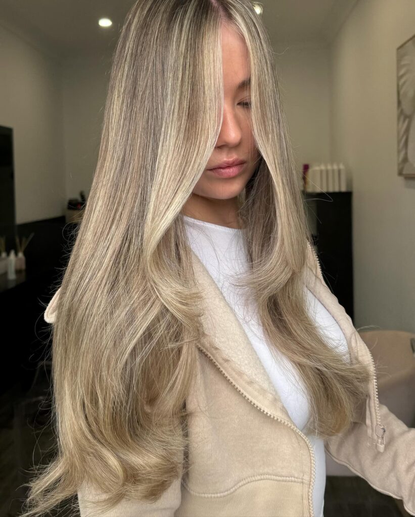 Long blonde layered hair with a sleek smooth finish.