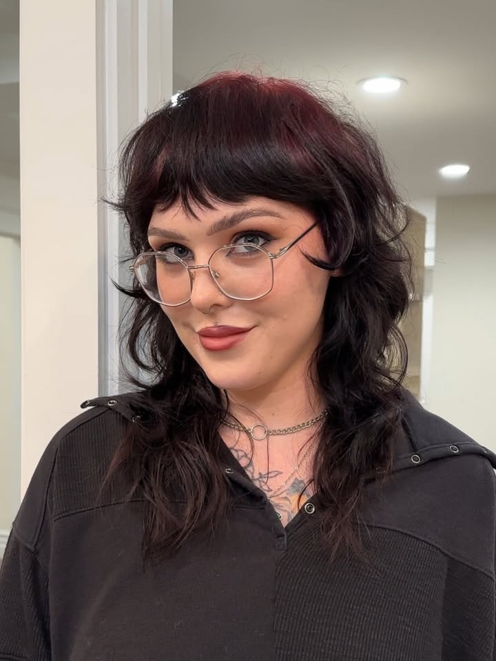 Medium length shaggy layered hair with short bangs and textured ends.