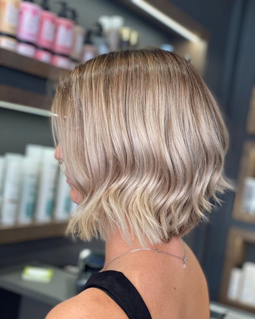 A woman with a platinum blonde wavy bob with smooth flowing waves.