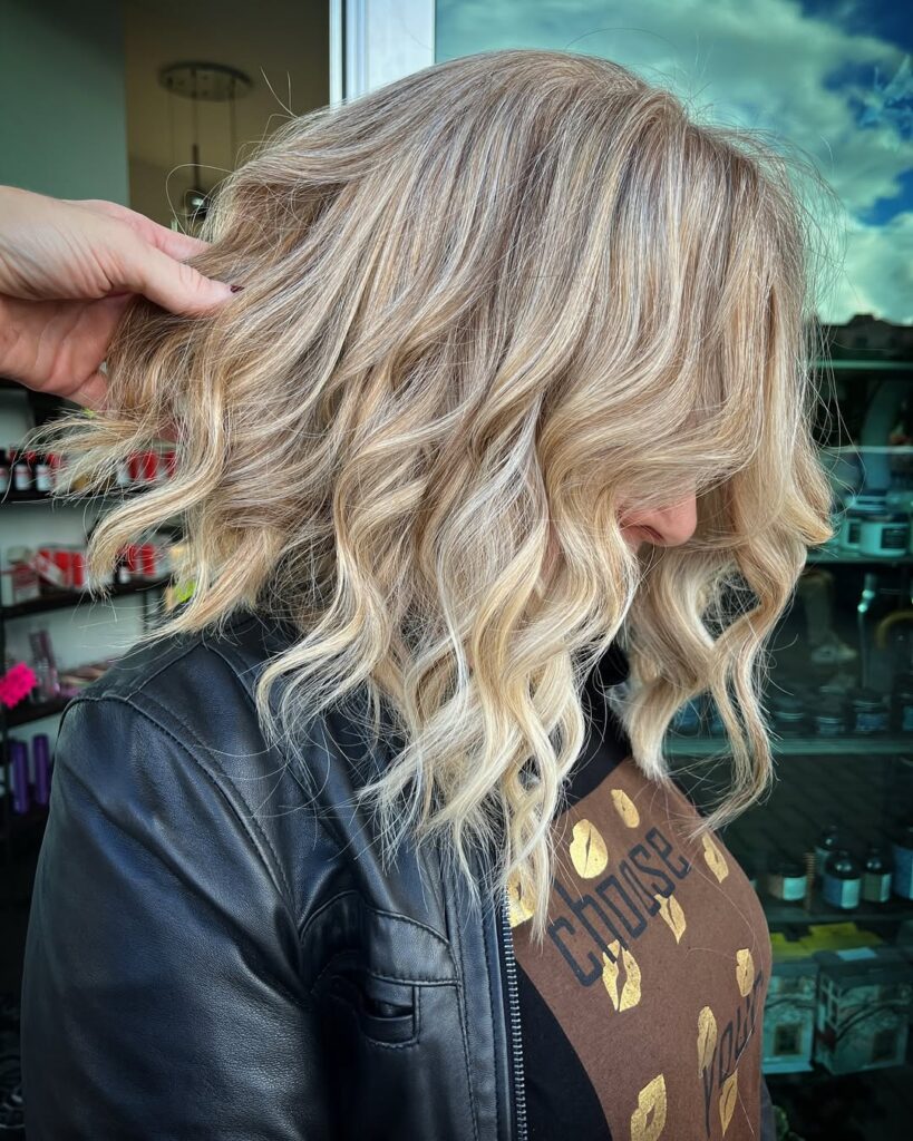 A woman with a loose blonde wavy bob with airy waves and soft texture.
