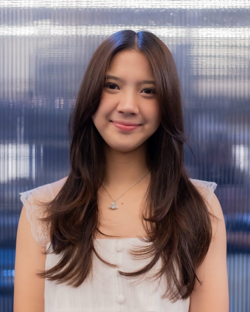 A woman with long glossy espresso brown hair featuring soft cascading layers and inward curved ends.