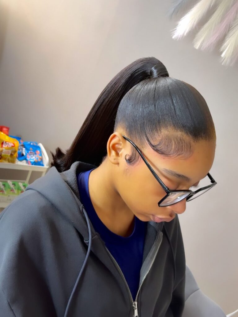 Dark hair styled in a high sleek ponytail with neatly laid edges and a smooth finish.