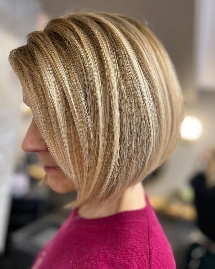 Short angled blonde bob with a smooth finish and longer front pieces.