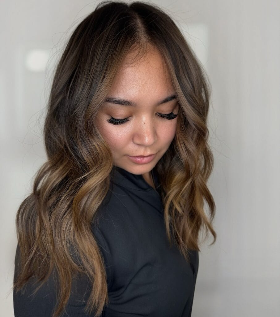 Long layered hair with loose waves and a soft center part for a clean everyday style.