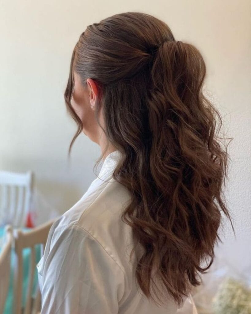 Long wavy hair styled in a half up ponytail with soft loose lengths.