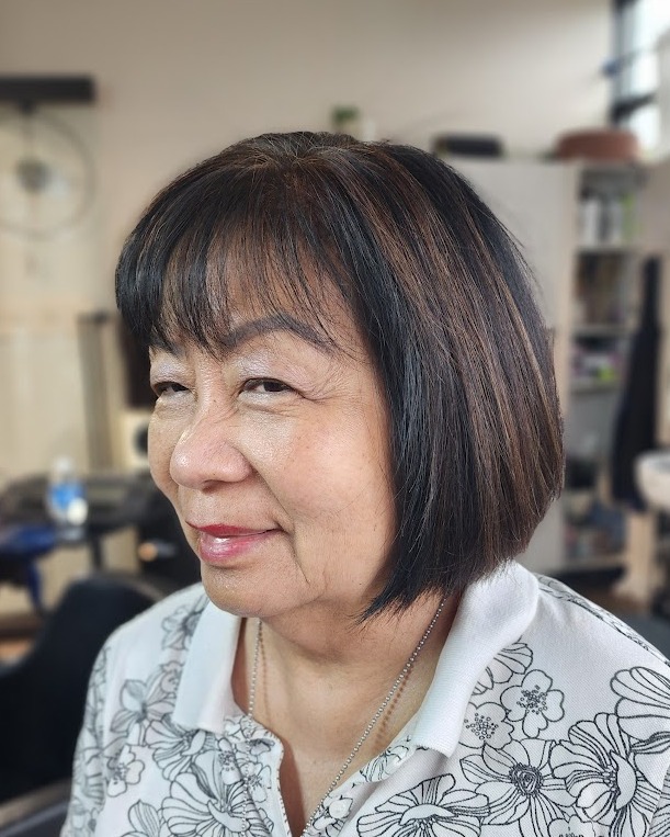 Rounded brunette bob with a short straight fringe and smooth shape.