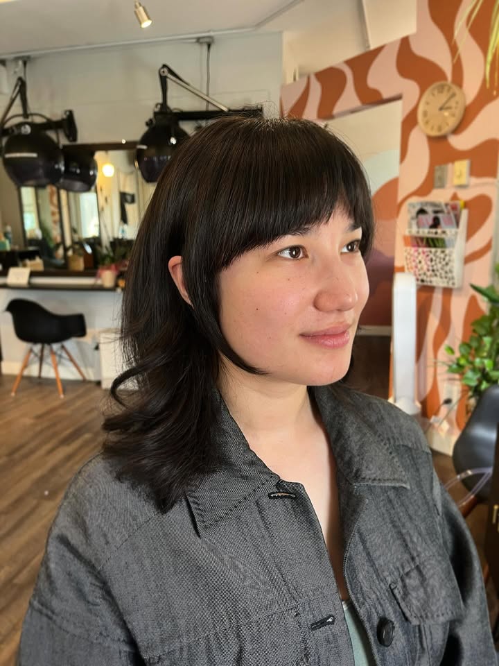 Short dark bob with rounded bangs and soft volumizing layers.