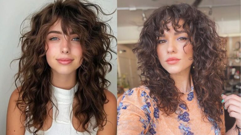 Long layered natural curly hair with soft volume and wispy curly bangs framing the face.