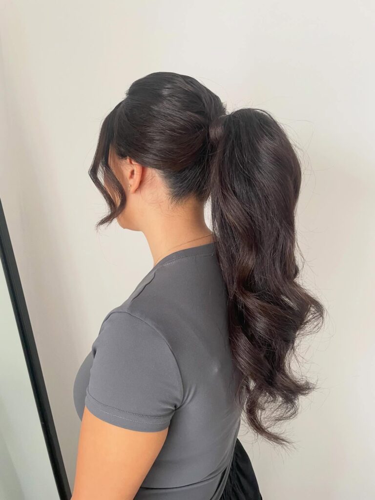 High ponytail with voluminous dark brunette waves and a lifted crown.