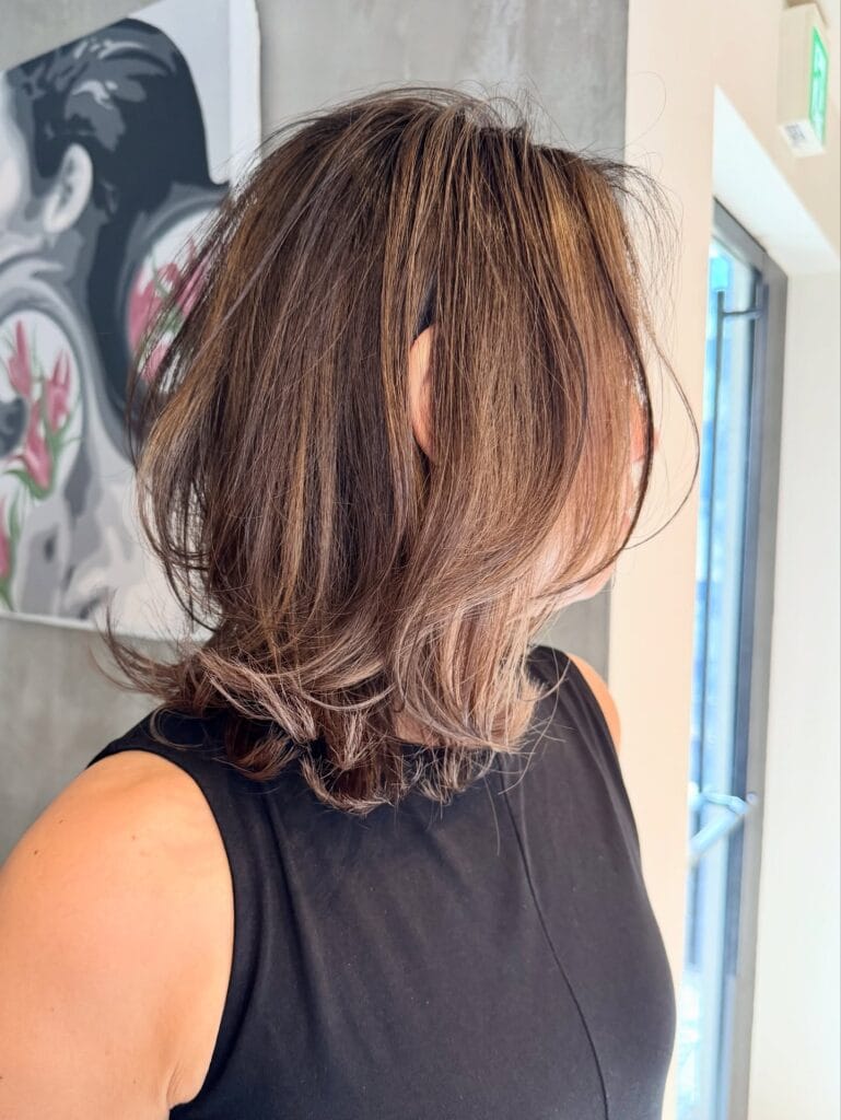 Medium-length brown wavy lob with soft layers and face-framing pieces.