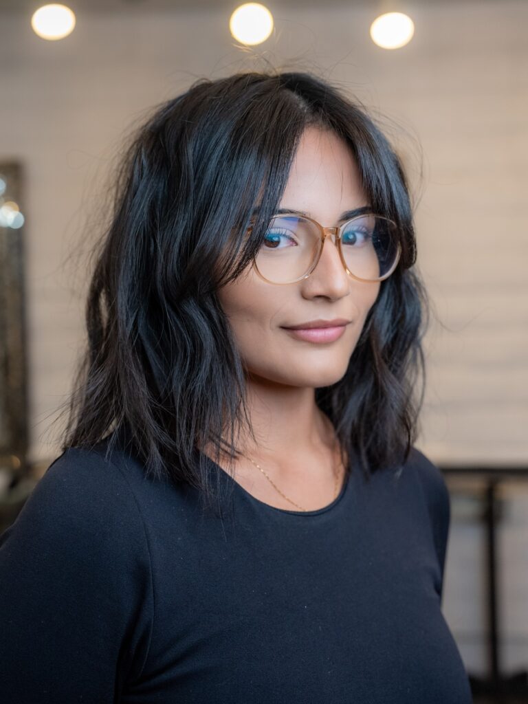 Medium length textured lob with soft waves and curtain layers in dark brunette tones.