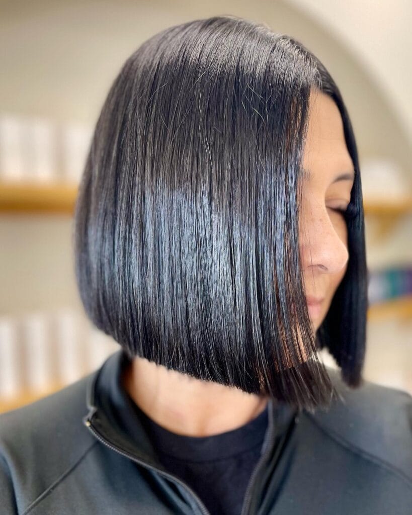 Dark blunt bob haircut styled straight with a glossy smooth finish.