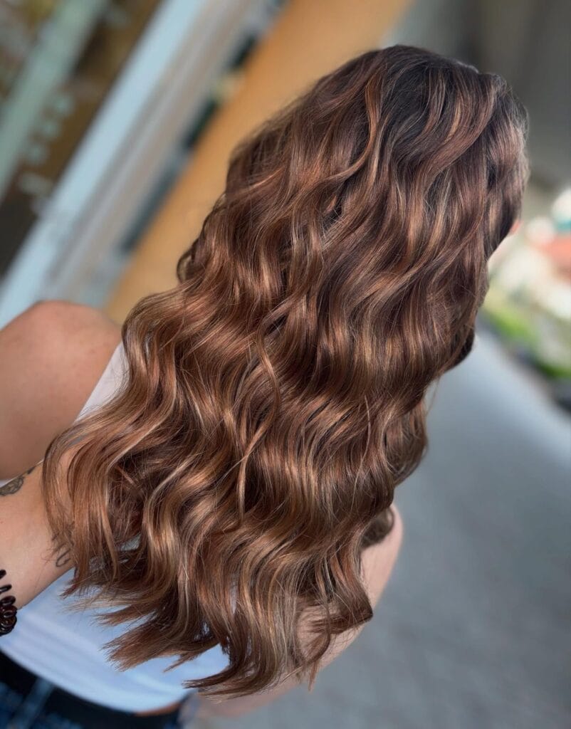 Long brunette hair with deep, defined waves and a glossy finish.