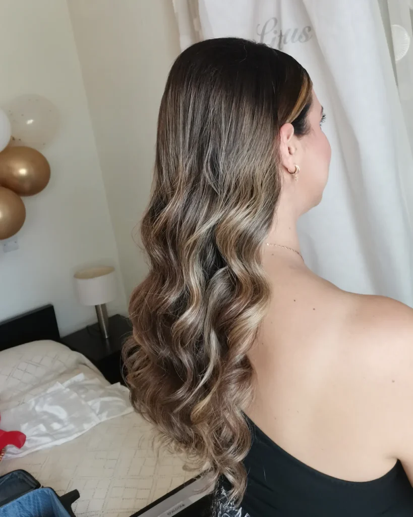 Long brunette hair with cool toned highlights and soft layered waves.