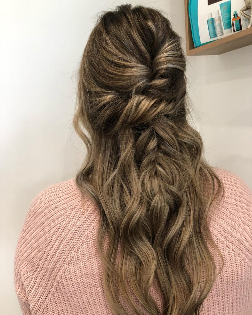 Long wavy hair styled half up with a twisted detail and loose texture.