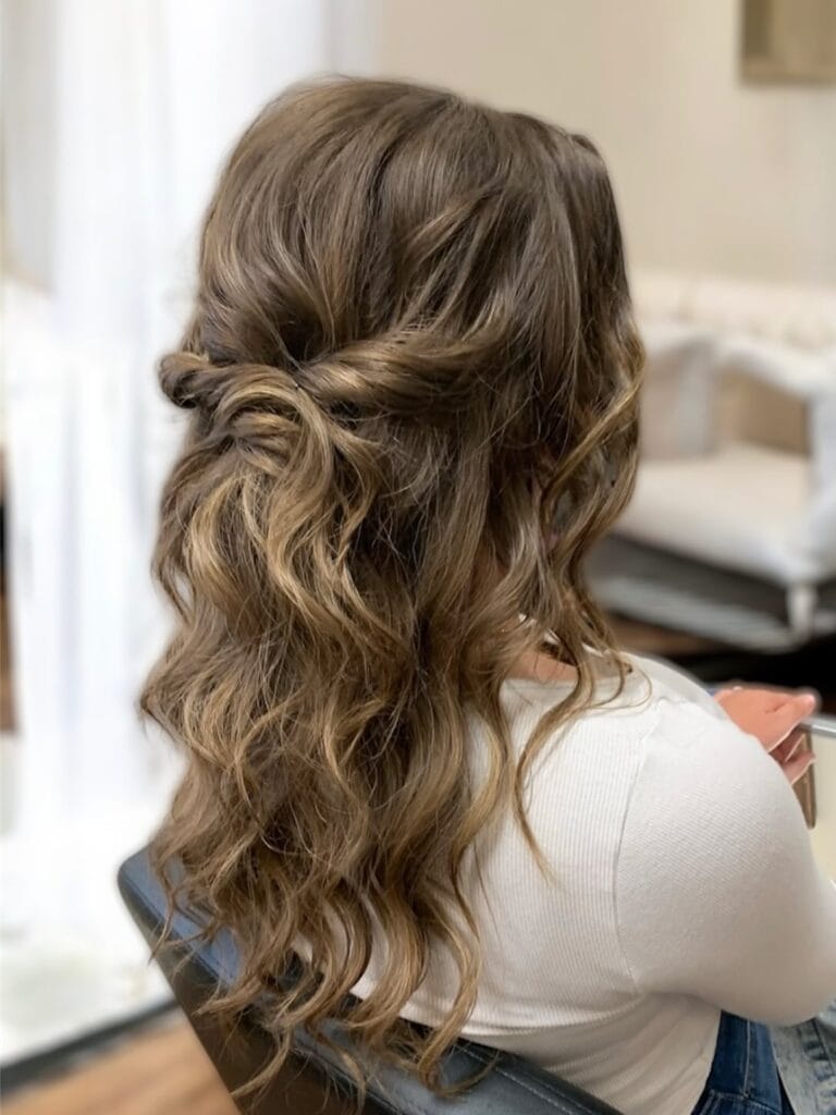 Long wavy hair styled half up with a soft twist and added volume.