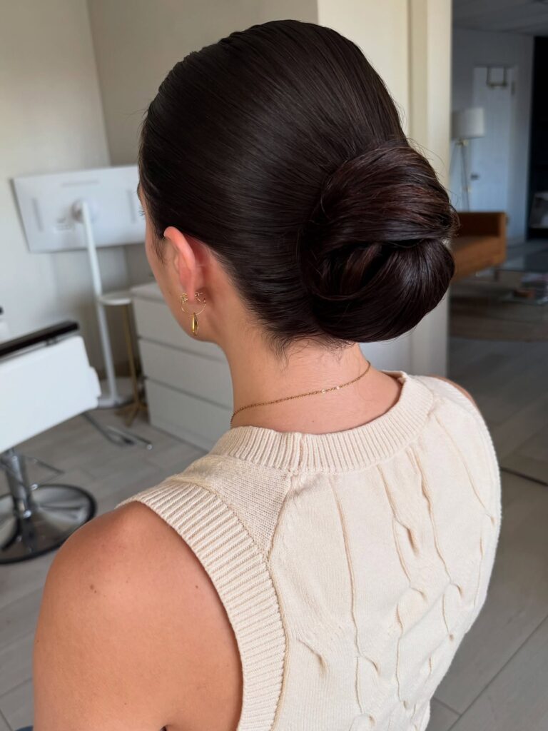 Dark hair styled into a polished low bun with a smooth crown.